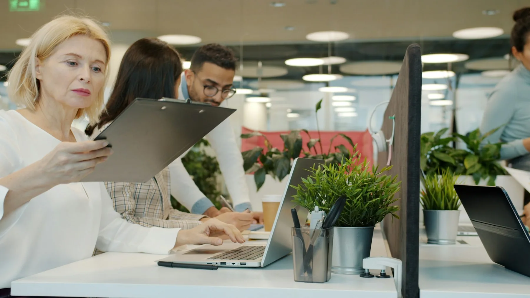 Colleagues reviewing office work together at a shared workstation.